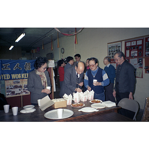 Chinese Progressive Association members gather around a table for dinner