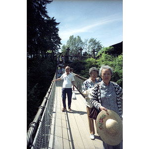 Chinese Progressive Association members cross the Capilano Suspension Bridge in British Columbia's rain forest