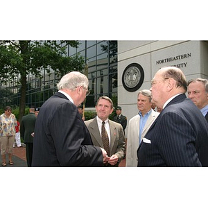 A group of men converse at the Veterans Memorial groundbreaking ceremony