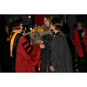 Students present Patricia Kiladis, a professor, with flowers during the School of Nursing convocation