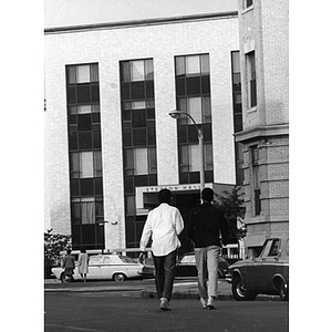 Two students walk across Hemenway Street toward Stetson Hall
