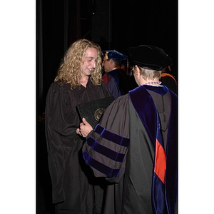 Faculty member presents student with certificate at School of Nursing convocation