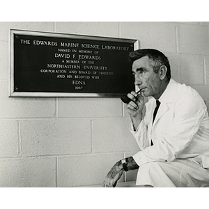 Dr. Nathan W. Riser in front of the Edwards Marine Science Laboratory plaque