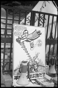 Protest sign depicting President Johnson dangling puppet Japanese prime minister and dropping bombs on Vietnam