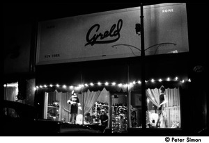Front of Cyreld boutique, Coolidge Corner, with window displays lit up at night