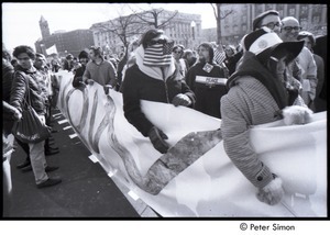 Protestors holding a large sign reading, 'bring all the troops home now'