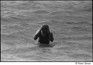 Ram Dass in the ocean with his hands on his head