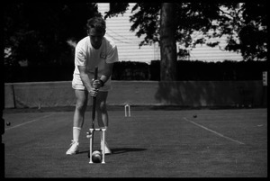 Croquet player hitting a ball through the wicket, Newport, R.I.