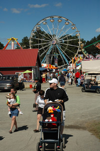 Franklin County Fair: a family walking through the fairgrounds, Ferris wheel in background