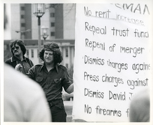 Board of Trustees fee increase demonstration: Charles Bagli with raised fist, holding sign