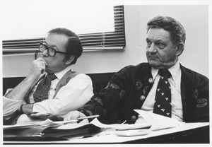 Two unidentified physical plant staff sitting at table