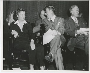 Arthur Godfrey seated on stage with staff at Institute Day