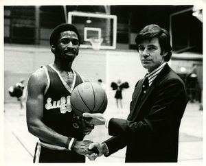 Suffolk University men's basketball player Donovan Little with Coach James E. Nelson after Little scored his 2000th point at a game against Brandeis, 1979