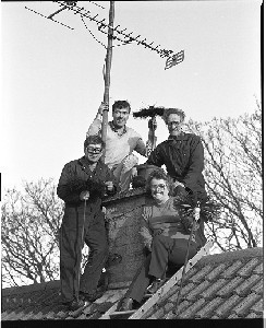 Crozier Family, Alfie and Mrs. Crozier and their two sons, chimney sweeps. Shots taken on the roof of their house beside the chimney, holding brushes. Alfie now deceased