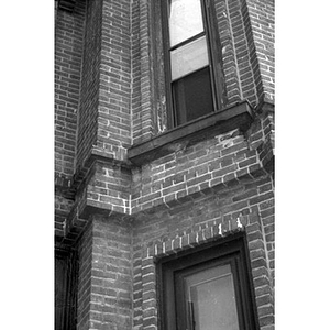 Windows set in the brick wall of an apartment building.