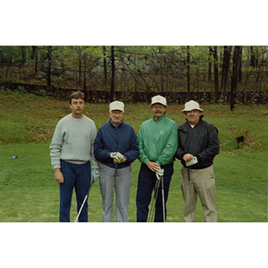 A four-man golf team posing with their clubs at a Boys and Girls Club Golf Tournament