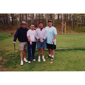 A four-man golf team posing with their clubs at the Charlestown Boys & Girls Club Annual Golf Tournament