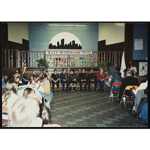 One woman handing a microphone to another while the guests look on at the MADD 1991 Poster and Essay Contest