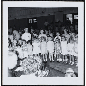 Contestants standing in front of the panel of judges with their brothers during a Boys' Club Little Sister Contest