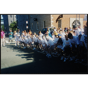 A large group of children gather at a start line for the Battle of Bunker Hill Road Race