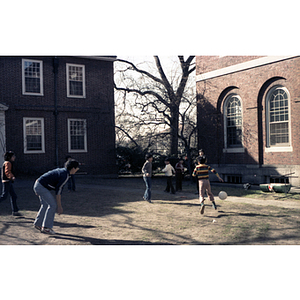 Children and young adults play kickball at a tutoring class picnic