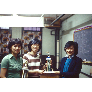 Winners of the table tennis tournament pose holding their own trophies with Suzanne Lee