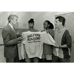 Balfour Academy Program Coordinator, Earl Stafford, and participants give President Curry a sweatshirt