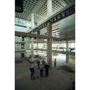 Construction workers stand in the gutted Ell Student Center before renovations