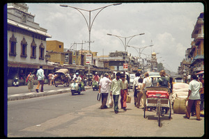 Busy street scene with scooters and pedicabs