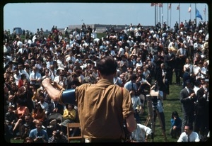 Pete Seeger greeting the crowd at an anti-Vietnam War demonstration: view from rear stage