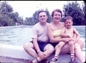 Couple and child, seated by a swimming pool: apparently a reprint of an older photograph