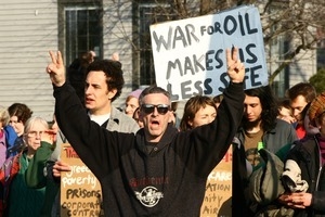Anti-war marcher in the crowd flashing peace signs: rally and march against the Iraq War