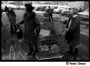 Women in a parking lot with shopping carts