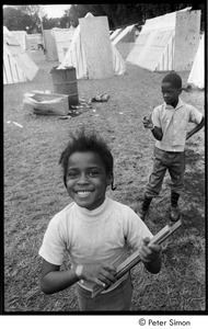 Young girl with playing with sticks, with a boy in the background