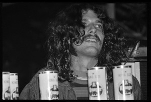 Man sitting behind beer cans as the band plays, Earth People's Park