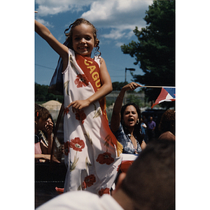 A young girl stands atop a parade float at the Festival Puertorriqueño