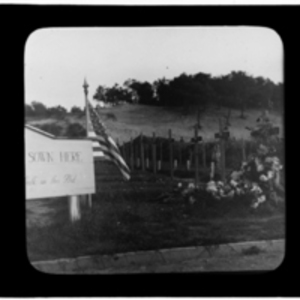 An American flag beside a cemetery sign
