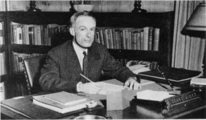 Suffolk University Dean Lester R. Ott, Lester (CAS 1945-1949), seated behind desk