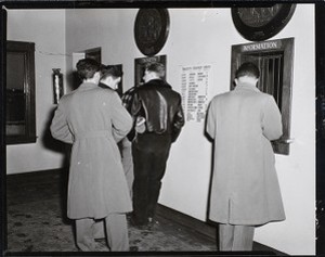 Four members of the Boston College Class of 1956 making puchases at ticket window