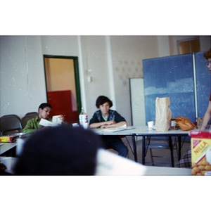 Three teenagers seated and participating in a classroom at La Alianza Hispana, Boston.