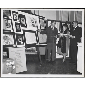 Judges Joseph L.C. Santoro, Mrs. Gertrude M. Tonsberg, and Arthur Parker select winning works in the Boys' Clubs of Boston Fine Arts Exhibit at the Bunker Hill Branch of the Boston Gas Company