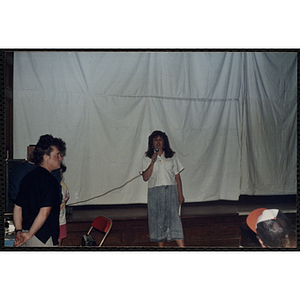 A woman speaks into a microphone at the Charlestown Boys and Girls Club Talent Show