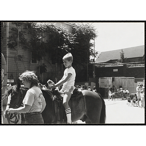 A boy rides a horse at a carnival