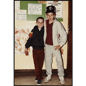 Two boys standing in front of a wall at an open house event