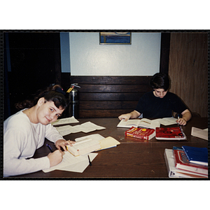 Two children sit at a table with pens and paper at the Tri-Club youth leadership event at the South Boston Clubhouse