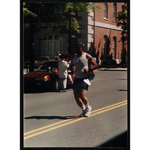 A man wearing headphones runs the Battle of Bunker Hill Road Race