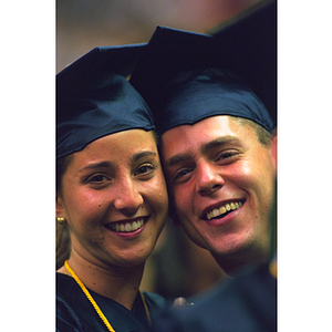 Two graduates in academic robes at commencement