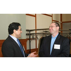 Two men laugh and converse at the Training Future Innovators Entrepreneurs Panel