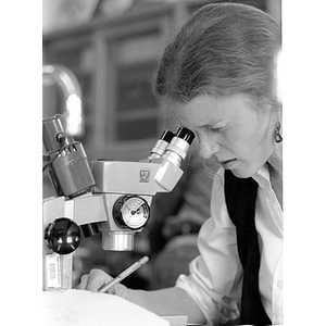 Female student looking through microscope