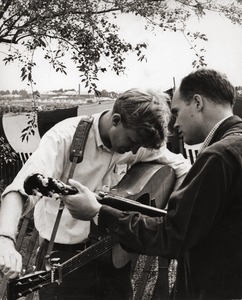 Jim Rooney, tuning his guitar, and Bill Keith (banjo) at the Newport Folk Festival